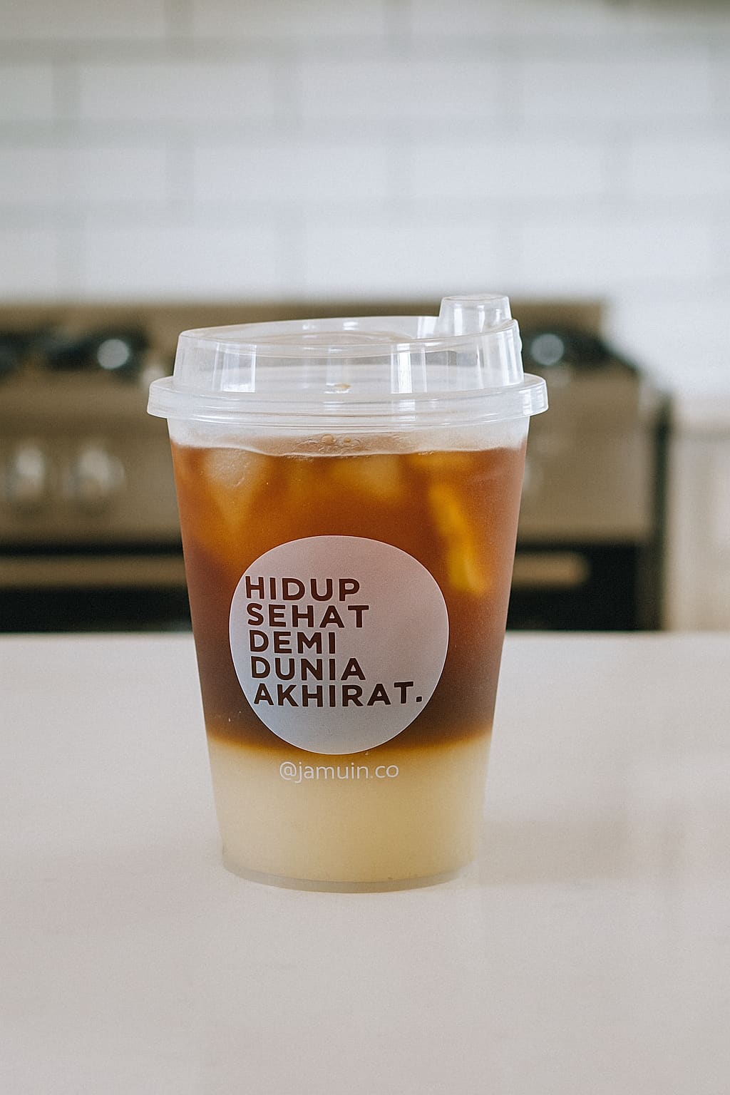 Segelas Americano Jamuin dengan gradasi kopi pekat di atas lapisan bening