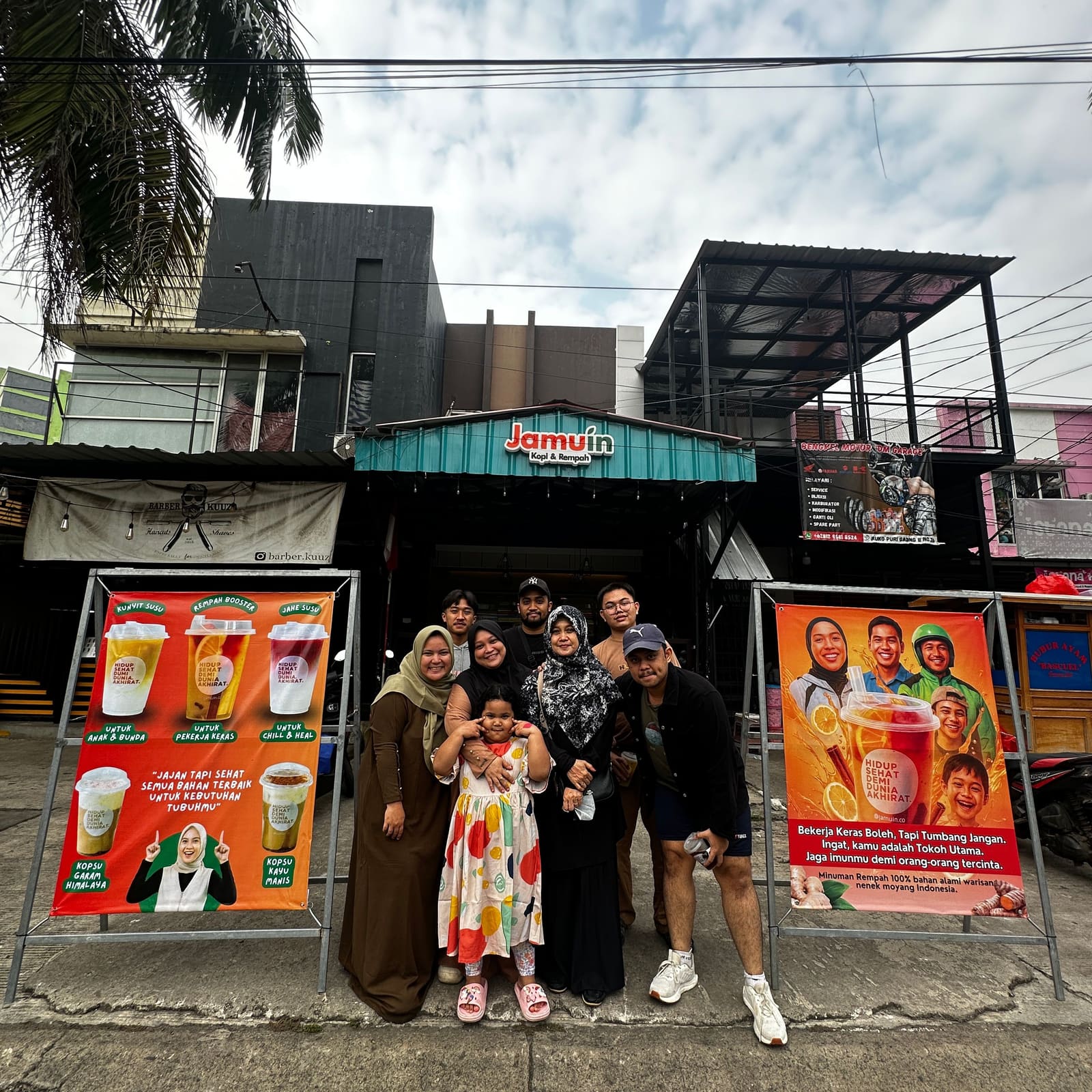 Keluarga pelanggan berfoto bersama di depan gerai Jamuin