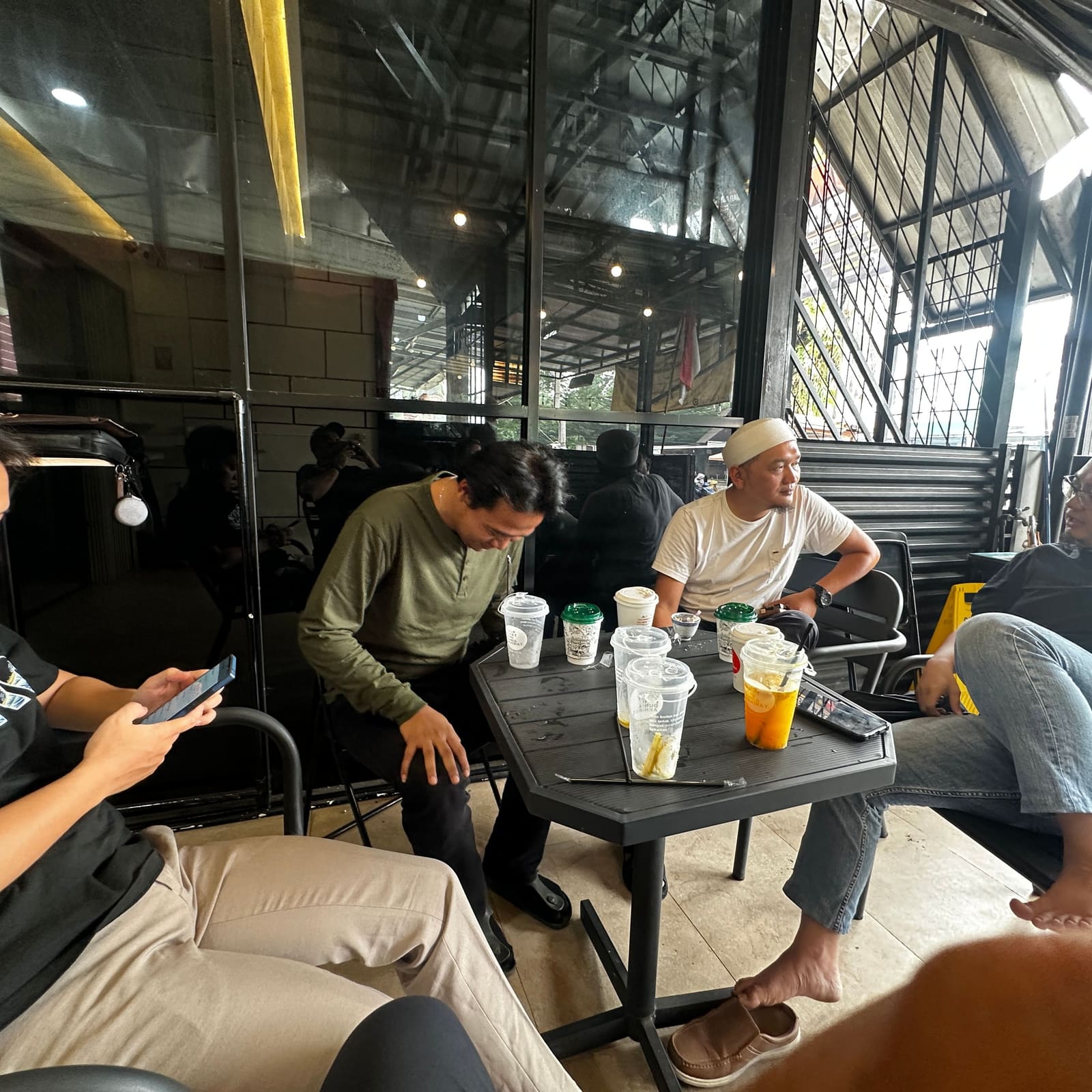 Sekelompok pelanggan mengobrol santai di meja luar gerai Jamuin